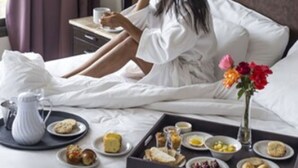 A hotel room with a bed, a bedside table with a lamp, and a tray of breakfast items. - Auberge Du Vin, Tupungato, Mendoza (Tupungato)