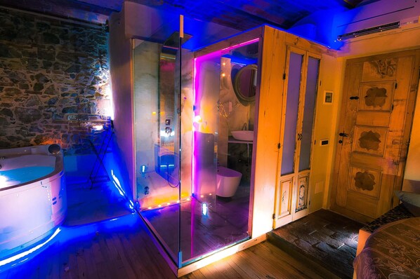 Un baño moderno con cabina de vidrio, una bañera y una puerta de madera.