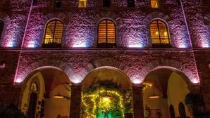 A historic building with arched windows and a central courtyard. - Castello di Montalbano (Florence)