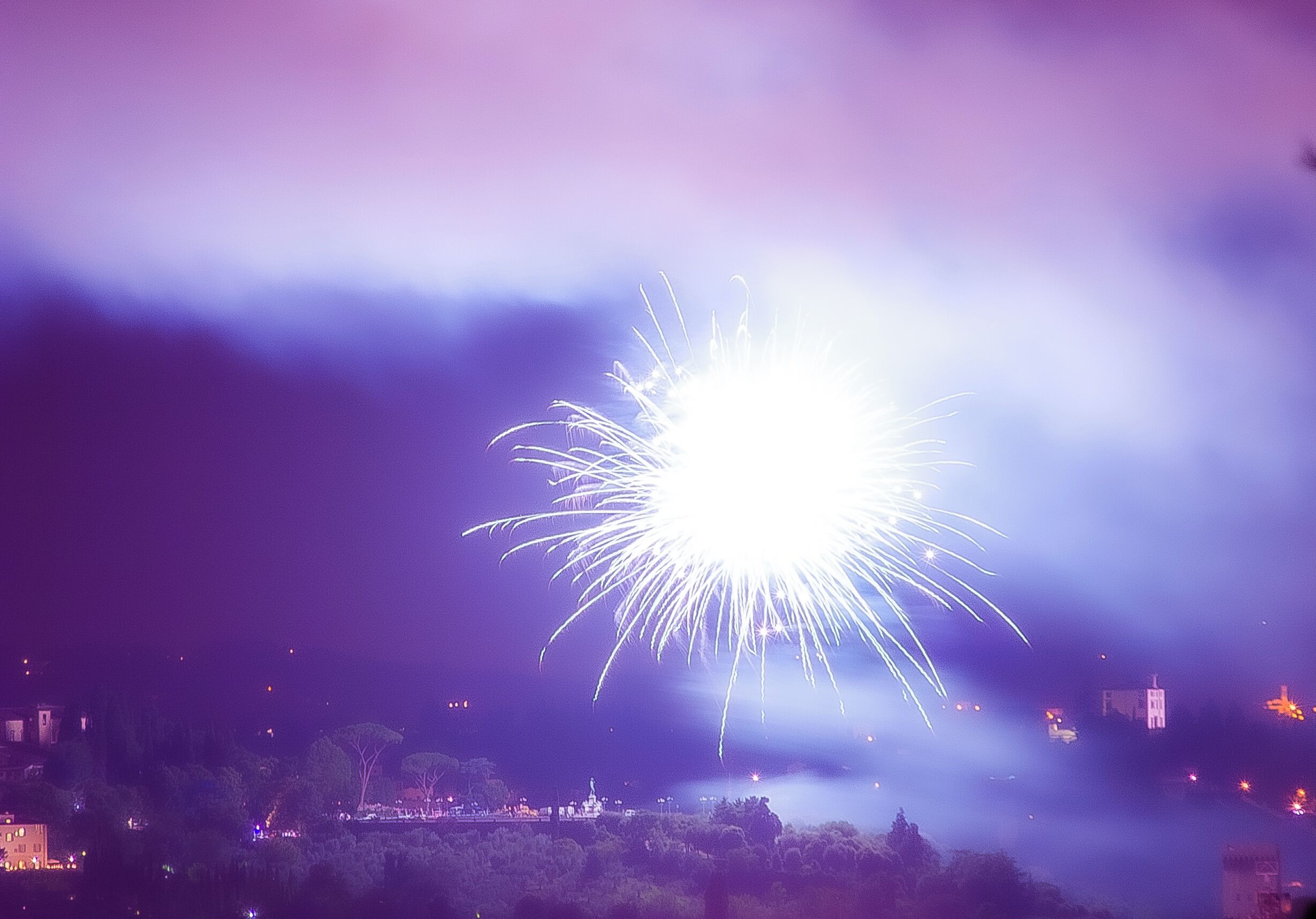 A nighttime scene with a bright firework display.