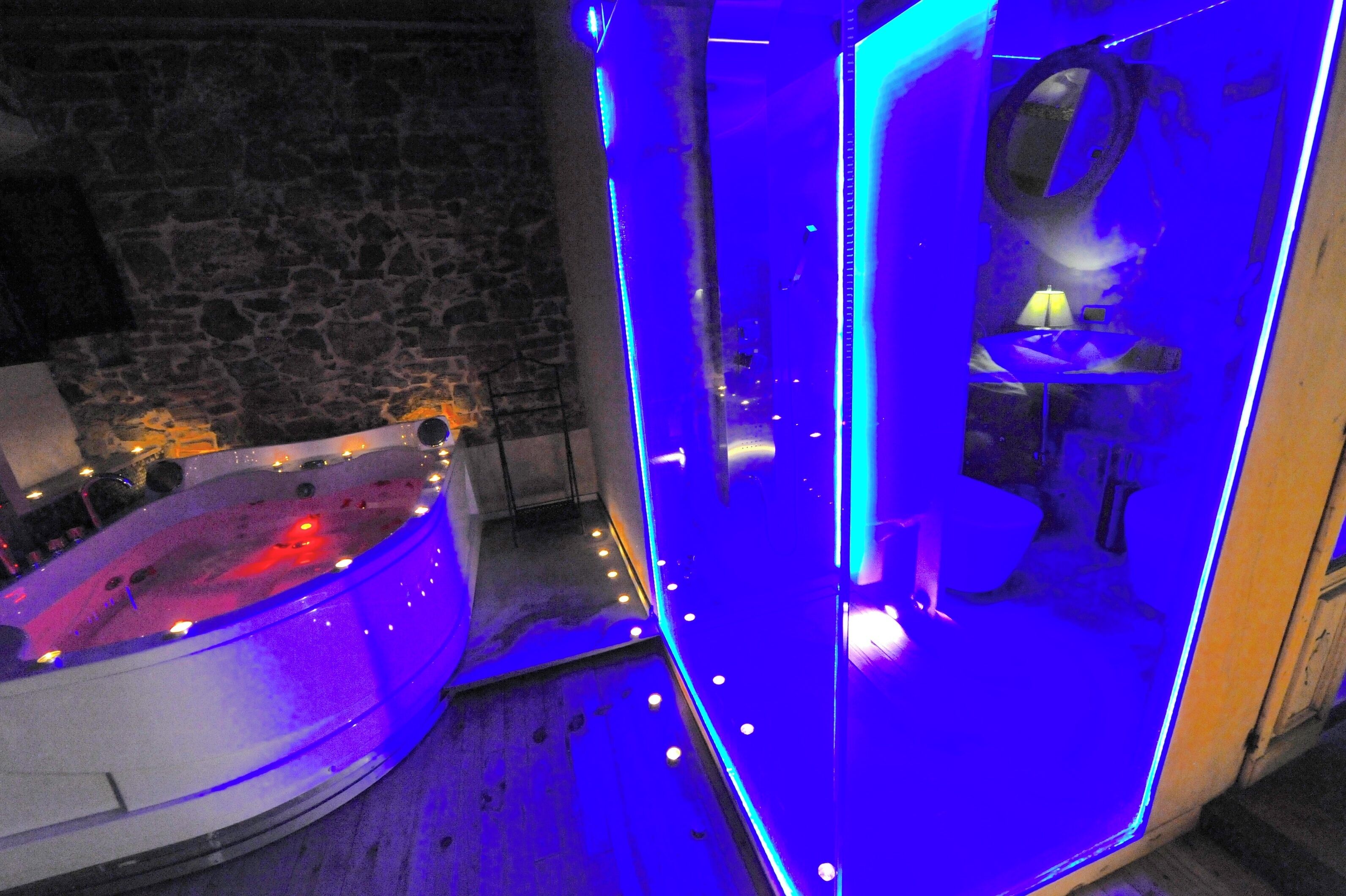 A spa area with a hot tub and a glass-enclosed shower area.