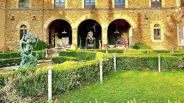 A historic stone building with multiple arches and a central courtyard. - Castello di Montalbano (Florence)
