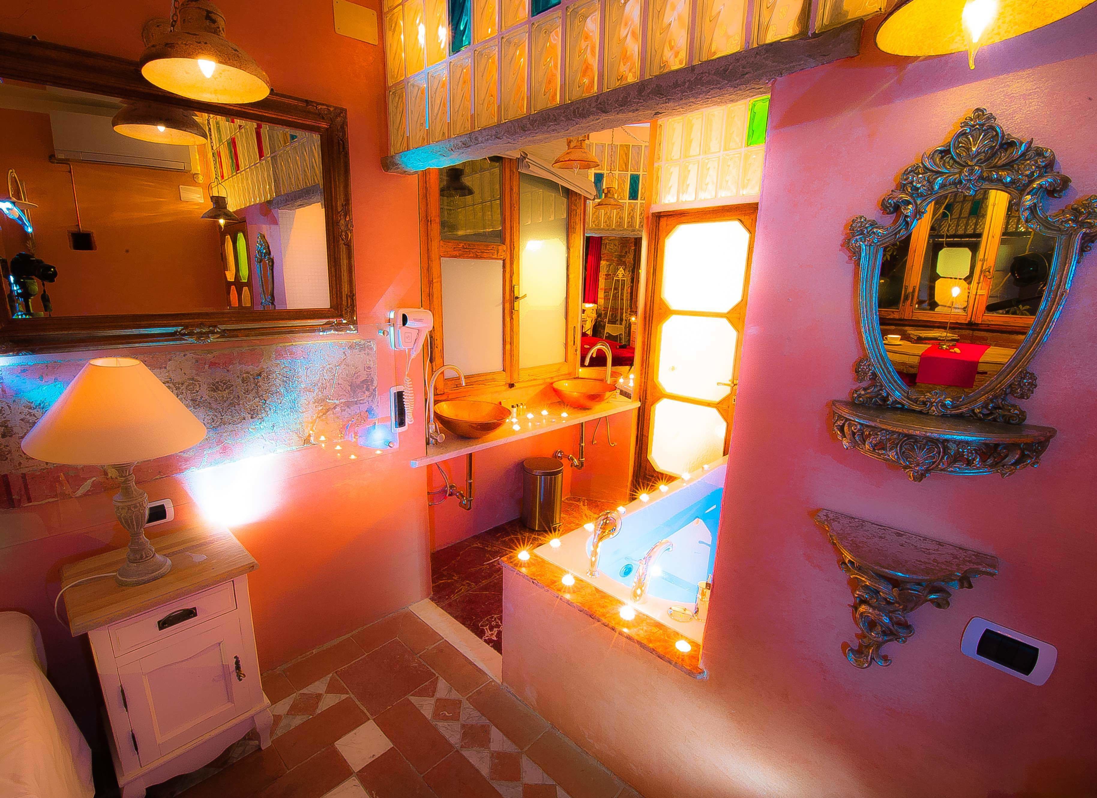 A bathroom with a sink, mirror, and a decorative wall.