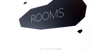 A black sign with "ROOMS" written on it, a staircase, and a geometric line. - Design Hostel 101Dalmatinac (Split)