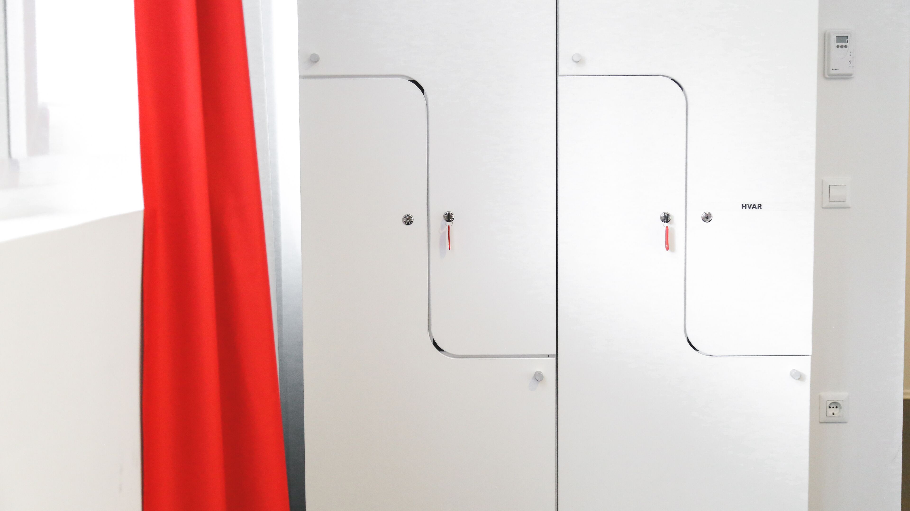 A white door with a red handle and a label 'HVAR' on it.