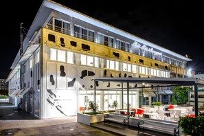 A modern building with a cafe area featuring outdoor seating and a covered walkway. - Design Hostel 101Dalmatinac (Split)