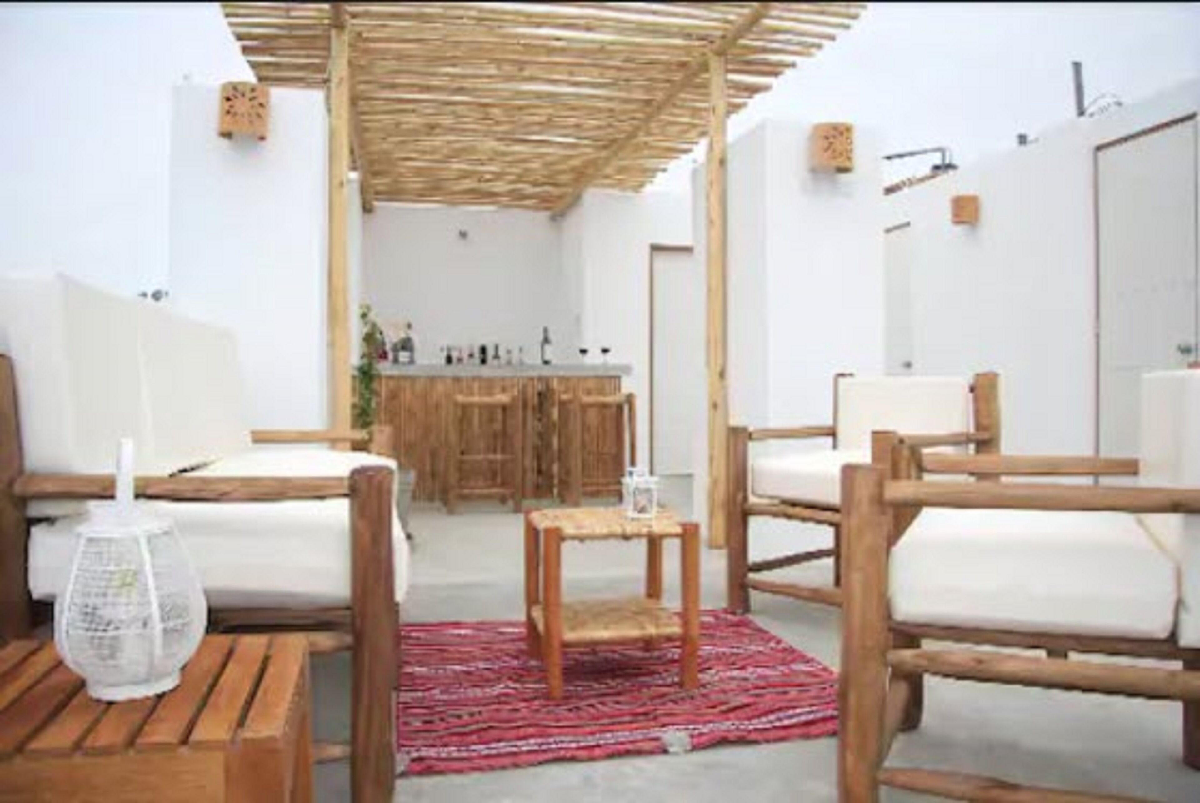 A cozy room with wooden furniture, a small table, and a red patterned rug.