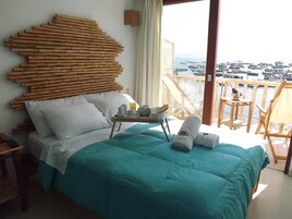 A bedroom with a bed, a bedside table, and a view of a marina.