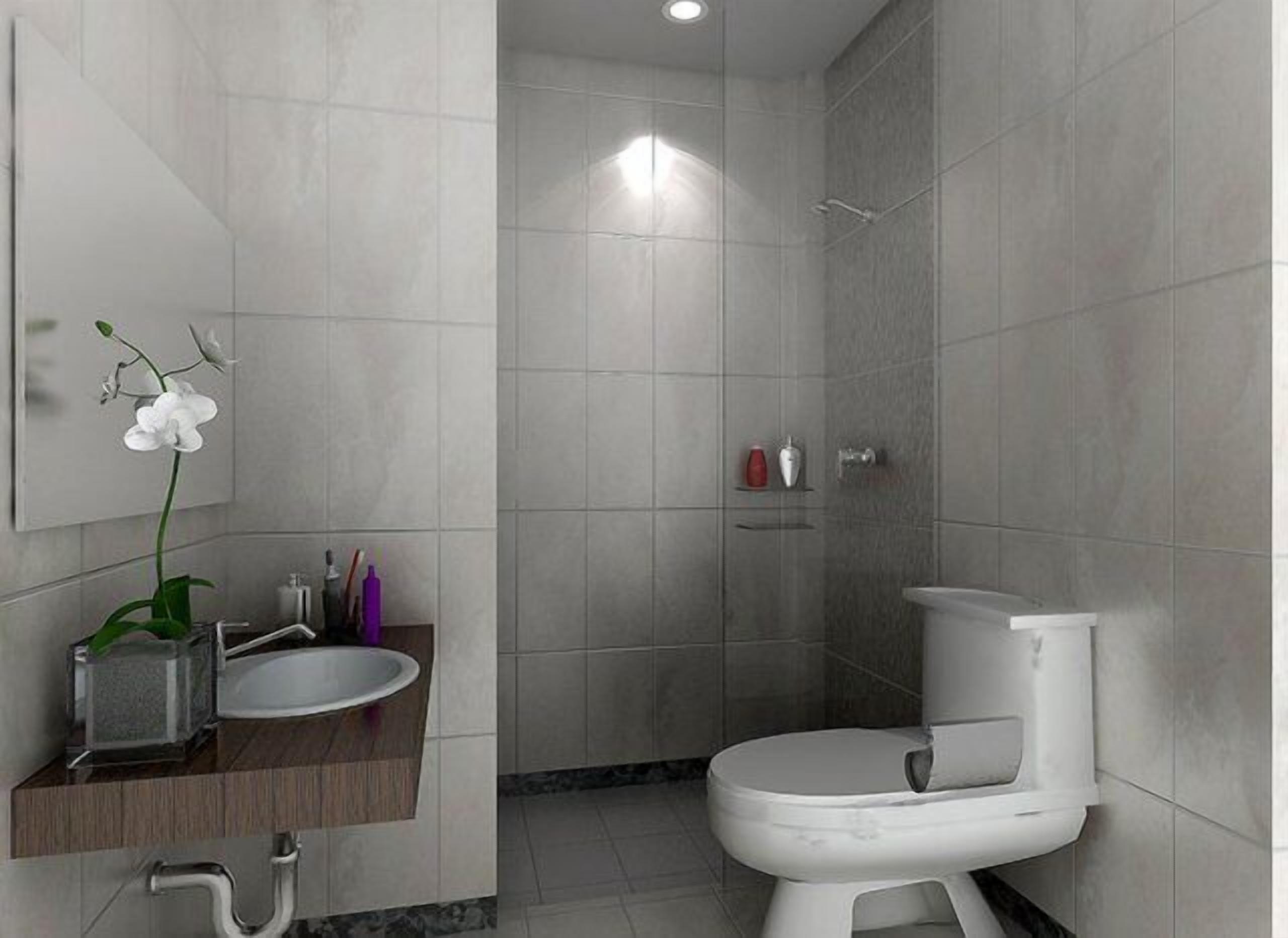 A modern bathroom with a white toilet, a sink with a marble countertop, and a shower area.