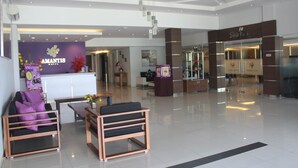 A modern hotel lobby with a reception desk, seating area, and a Shalimar restaurant. - Amantis Hotel (Demak)