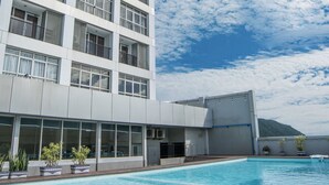 A modern hotel with a swimming pool, large windows, and a mountain view. - FOX Hotel Gorontalo (Gorontalo)