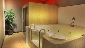 A modern bathroom with a large bathtub, wooden panel walls, and a potted plant. - FOX Hotel Gorontalo (Gorontalo)