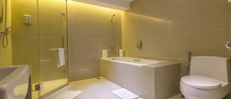 A modern bathroom with a glass-enclosed shower, a freestanding bathtub, and a toilet.