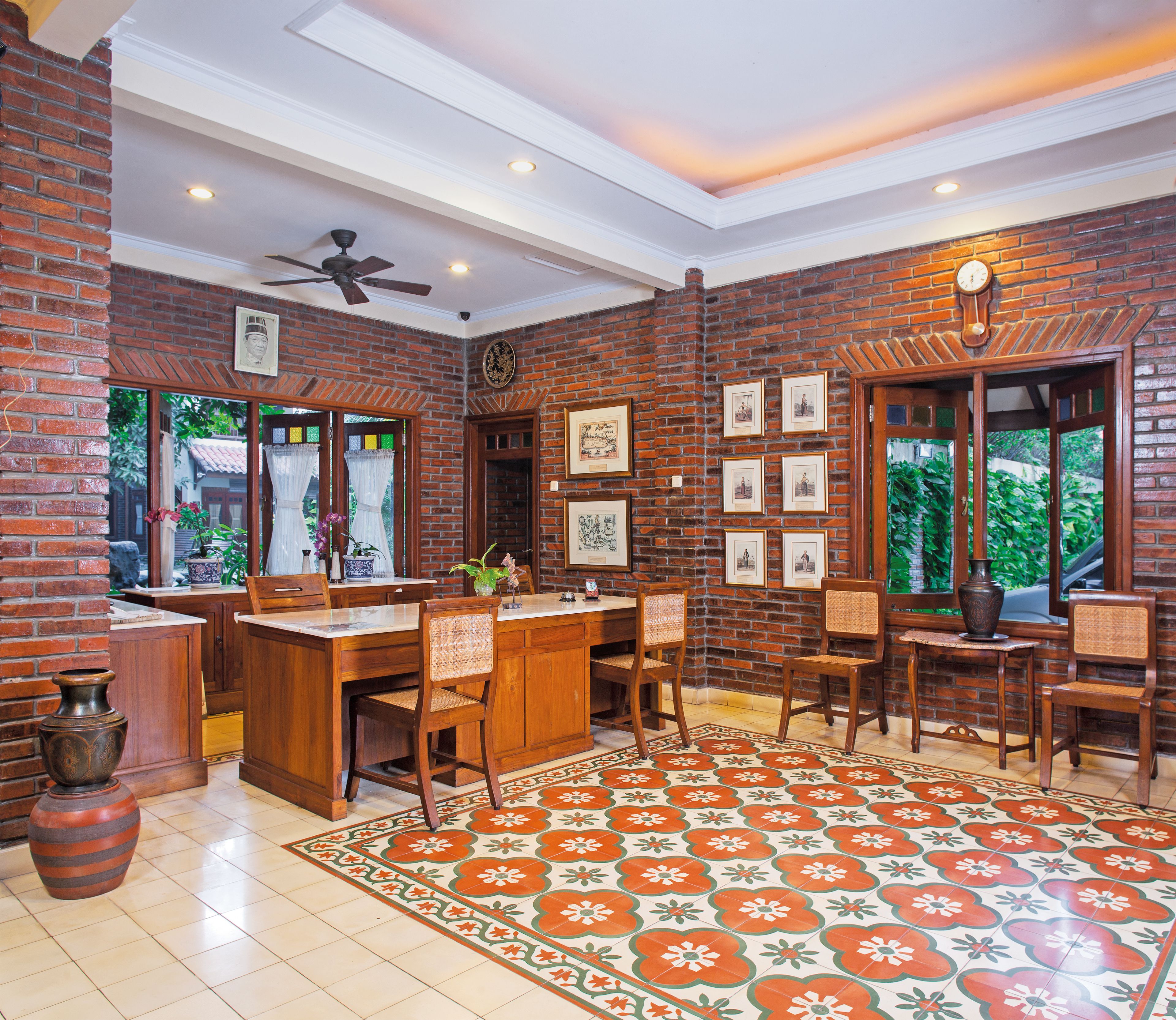 A kitchen with a brick wall, wooden furniture, and a tiled floor.