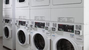 A row of stacked front-loading washing machines in a commercial laundry facility.