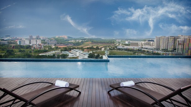 A rooftop pool area with two lounge chairs and a view of a cityscape. - Citadines DPulze Cyberjaya (Cyberjaya)