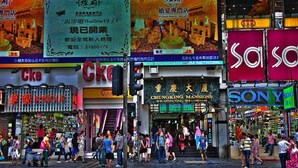 A busy street with various shops including a karaoke bar, a clothing store, and a Sony store. - Manila Hotel - Hostel (Kowloon)