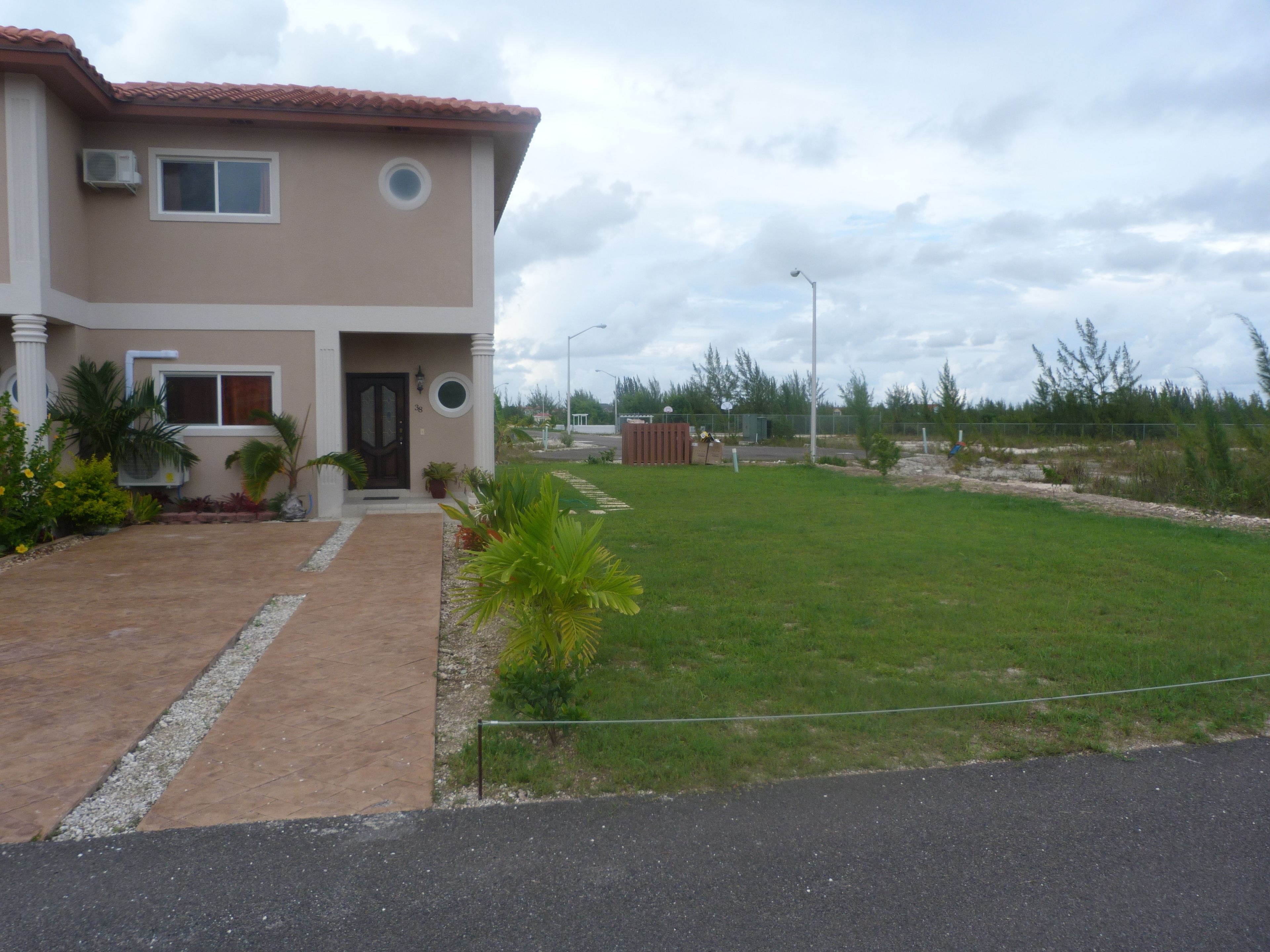 A two-story house with a front entrance, a paved driveway, and a well-maintained lawn.