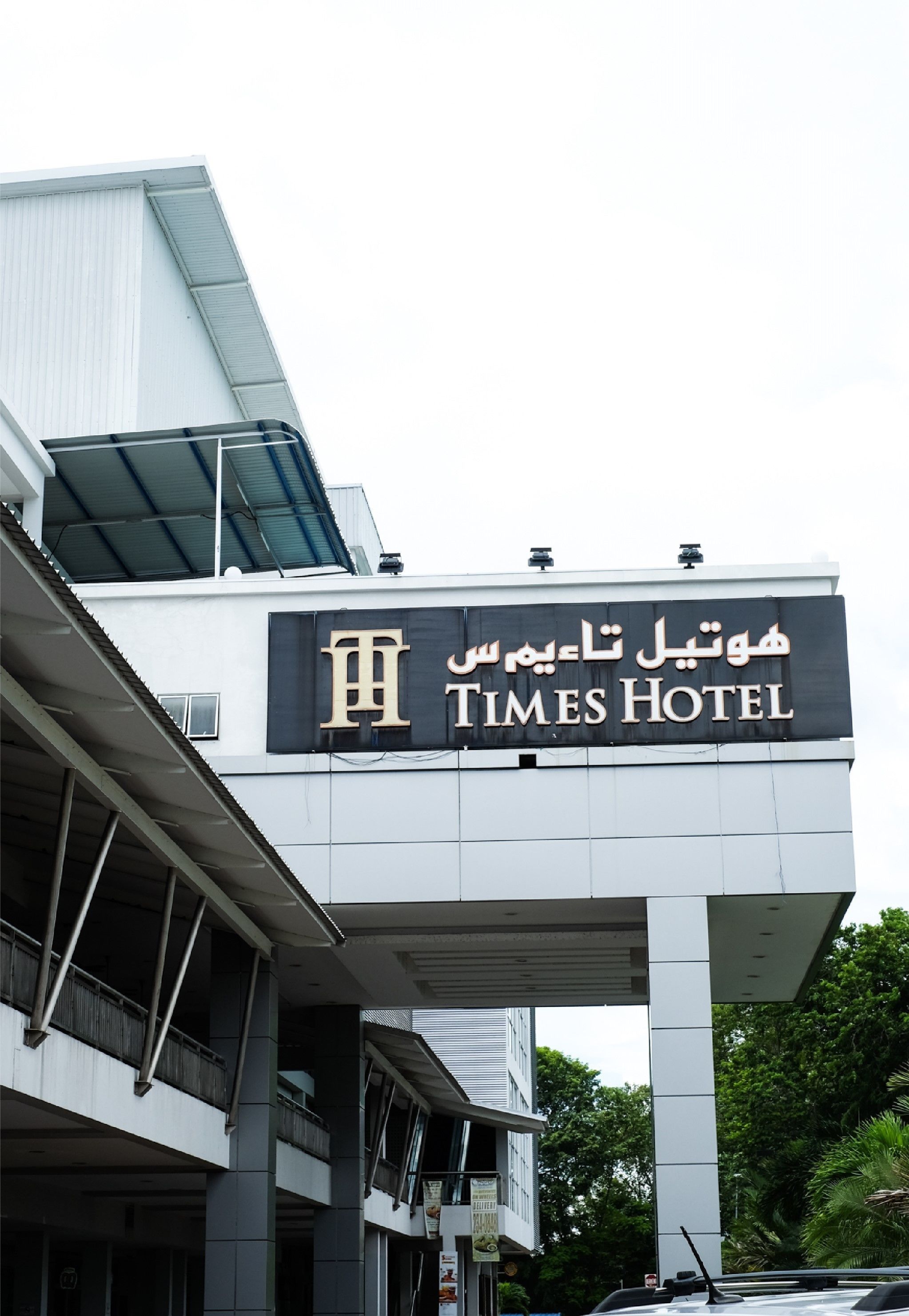 The exterior of the Times Hotel with a prominent sign displaying the hotel's name in both Arabic and English.