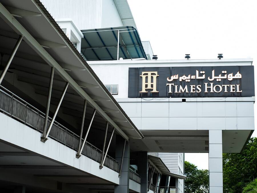 Letrero del hotel Times con texto en árabe y diseño arquitectónico moderno.