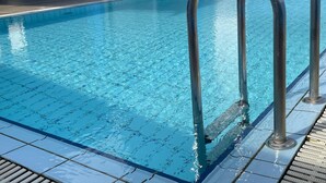 A swimming pool with clear blue water and metal handrails. - Times Hotel (Bandar Seri Begawan)