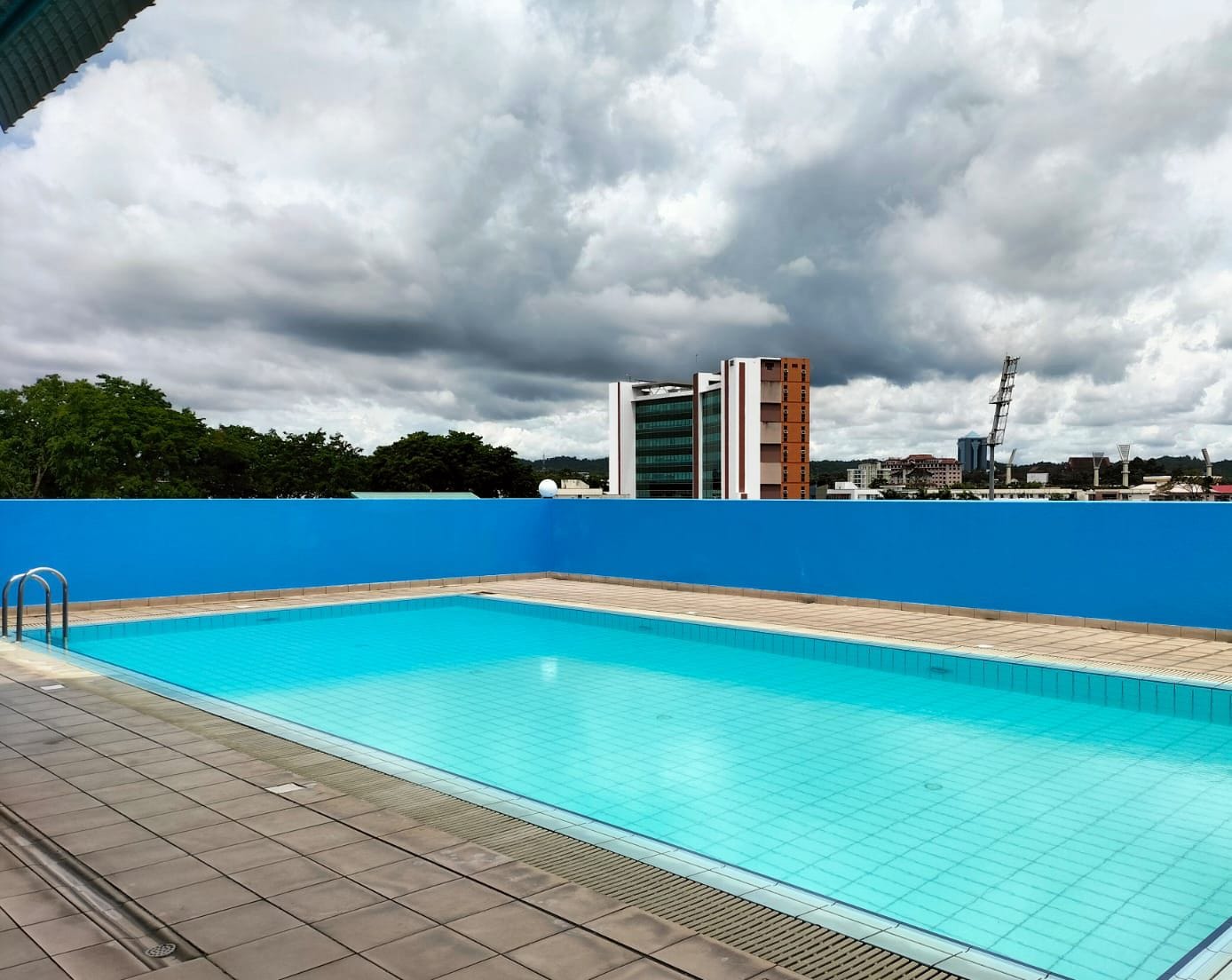 Ein Swimmingpool mit blauer Umrandung, einer Fliesenveranda und einem Schild mit der Aufschrift 120 Meter.