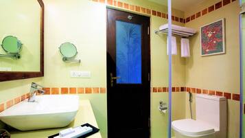 A bathroom with a sink, mirror, toilet, and a door with a decorative panel.