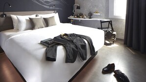 A modern hotel room with a large bed, a desk, and a window with curtains. - ARTOTEL Thamrin Jakarta (Jakarta)