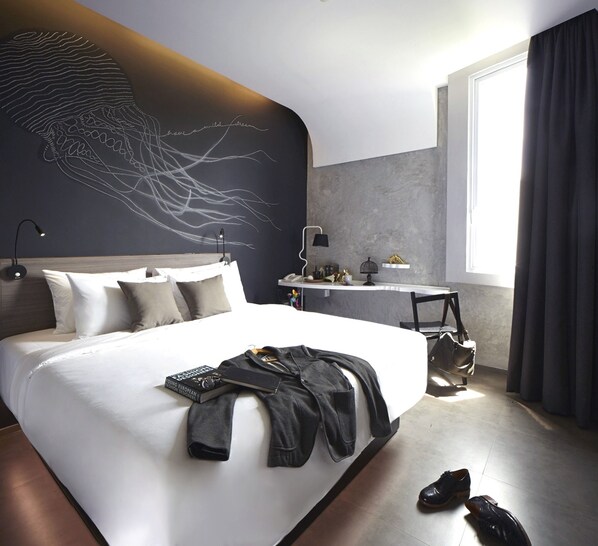 A modern hotel room with a large bed, a desk, and a window with curtains. - ARTOTEL Thamrin Jakarta (Jakarta)