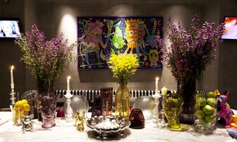 A table with various decorative items including vases, candles, and figurines.