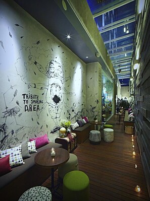 A modern lounge area with a mural, seating, and a wooden floor. - ARTOTEL Thamrin Jakarta (Jakarta)