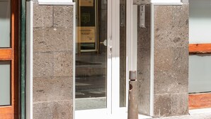 The entrance to Hotel Las Palmas Urban Center with a glass door, a reception desk, and a sign above the door. - Hotel Las Palmas Urban Center (Las Palmas de Gran Canaria)