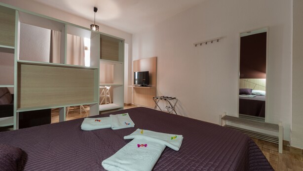A hotel room with a large bed, a TV, a mirror, and a wardrobe. - Hotel Las Palmas Urban Center (Las Palmas de Gran Canaria)
