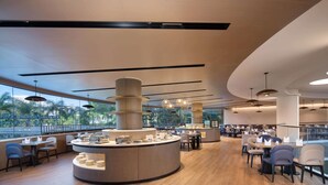 Un restaurante moderno con una barra central, varias mesas y sillas.