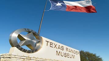 Une pancarte du musée des Texas Rangers, avec un mât de drapeau et le drapeau de l’État du Texas.