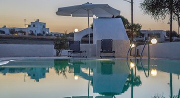Una piscina al aire libre, sombrillas, tumbonas
