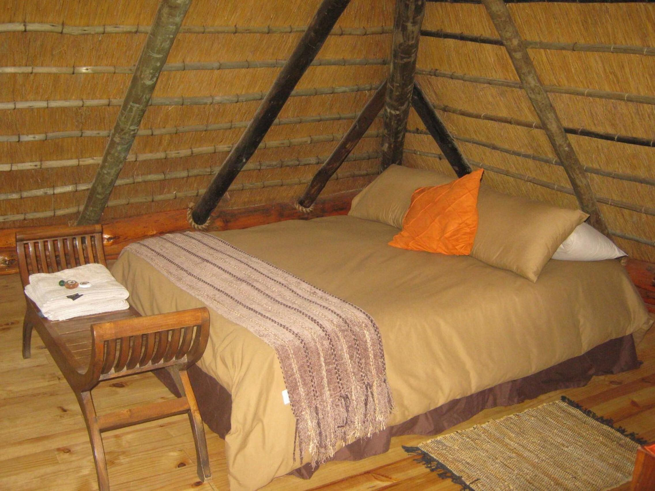 Une pièce chaleureuse et rustique, avec un lit, une chaise et une petite table.
