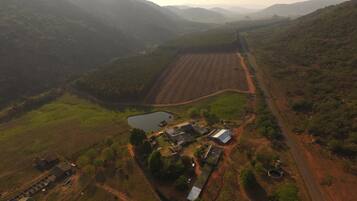 An aerial view of a rural landscape with fields, a small pond, and scattered buildings.