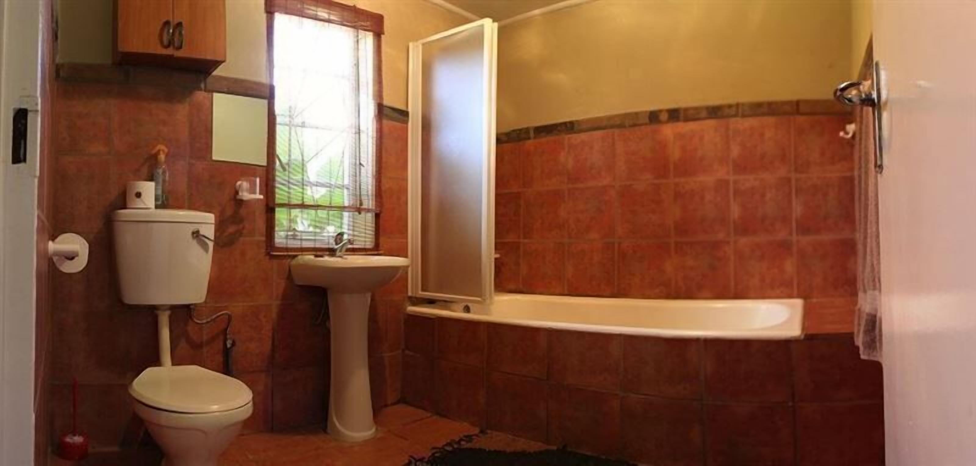 A bathroom with a toilet, sink, and shower.