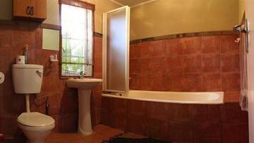 A bathroom with a toilet, sink, and shower.