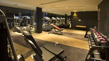 A modern gym with various exercise equipment, including treadmills, weight machines, and free weights.