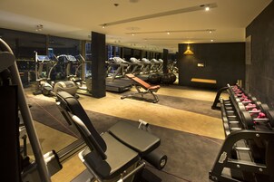 A modern gym with various exercise equipment, including treadmills, weight machines, and free weights.