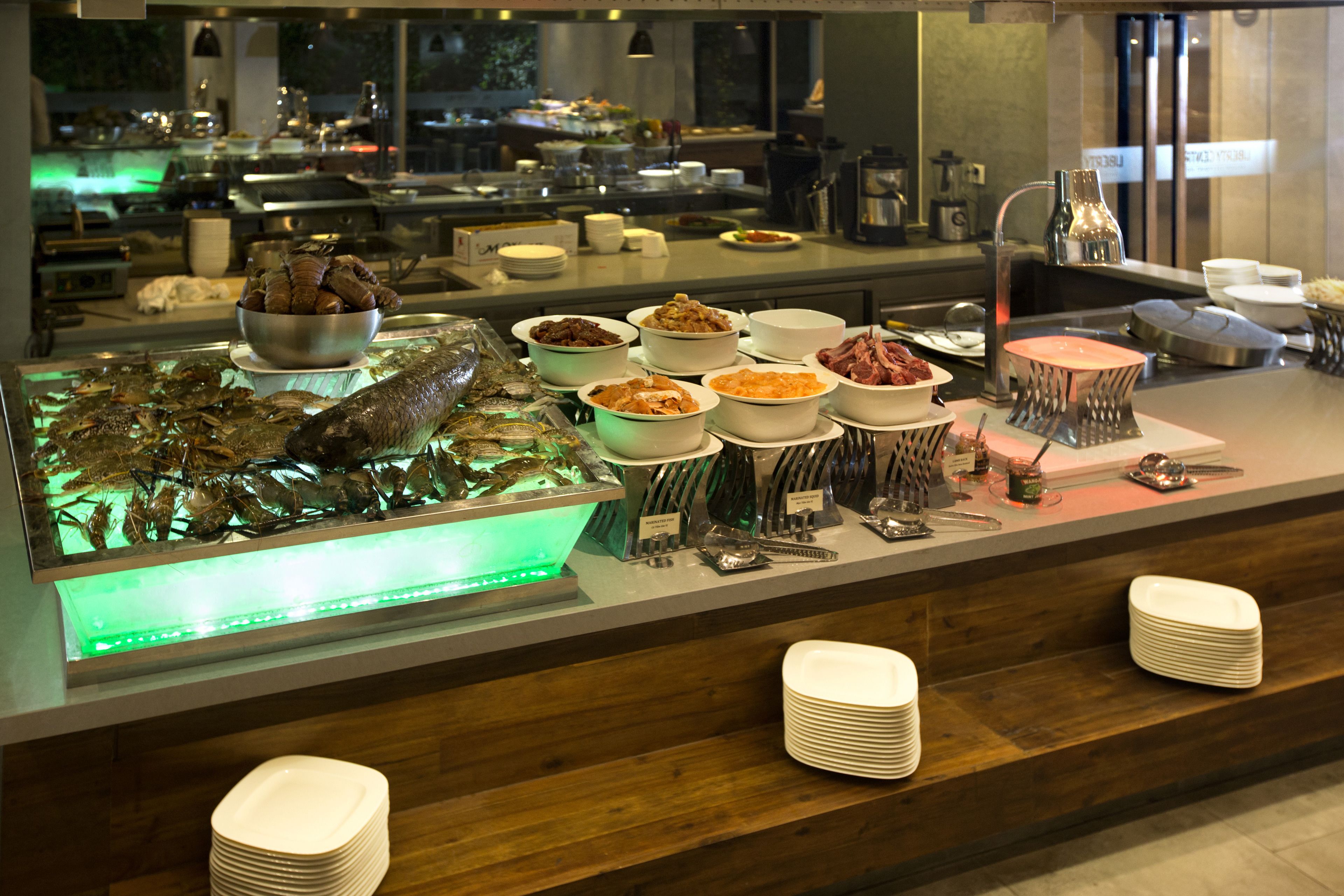 A buffet with various dishes and seafood displayed on a counter.