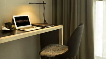A modern workspace with a laptop, desk lamp, and chair.