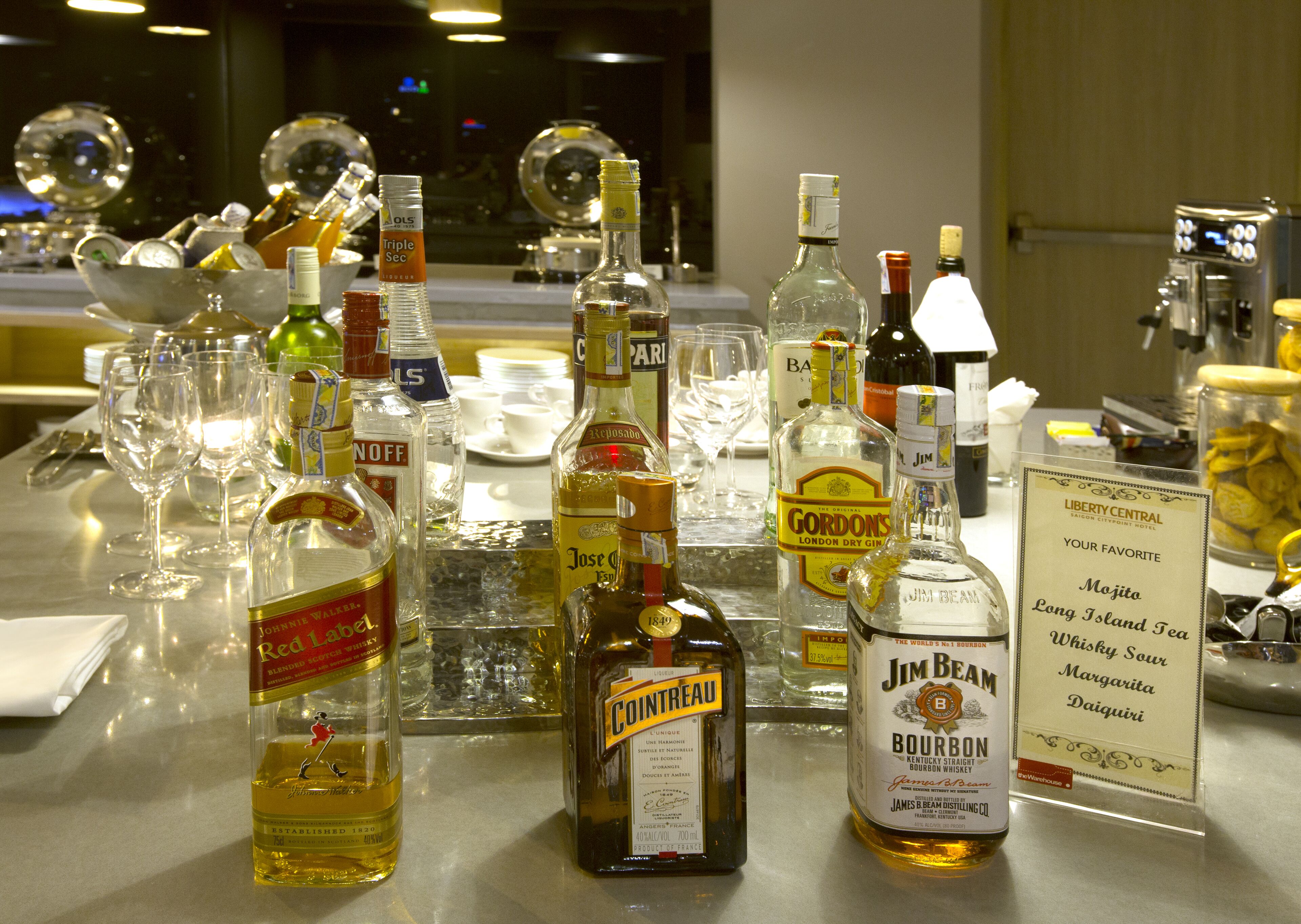 A bar area with various bottles of alcohol and glasses.