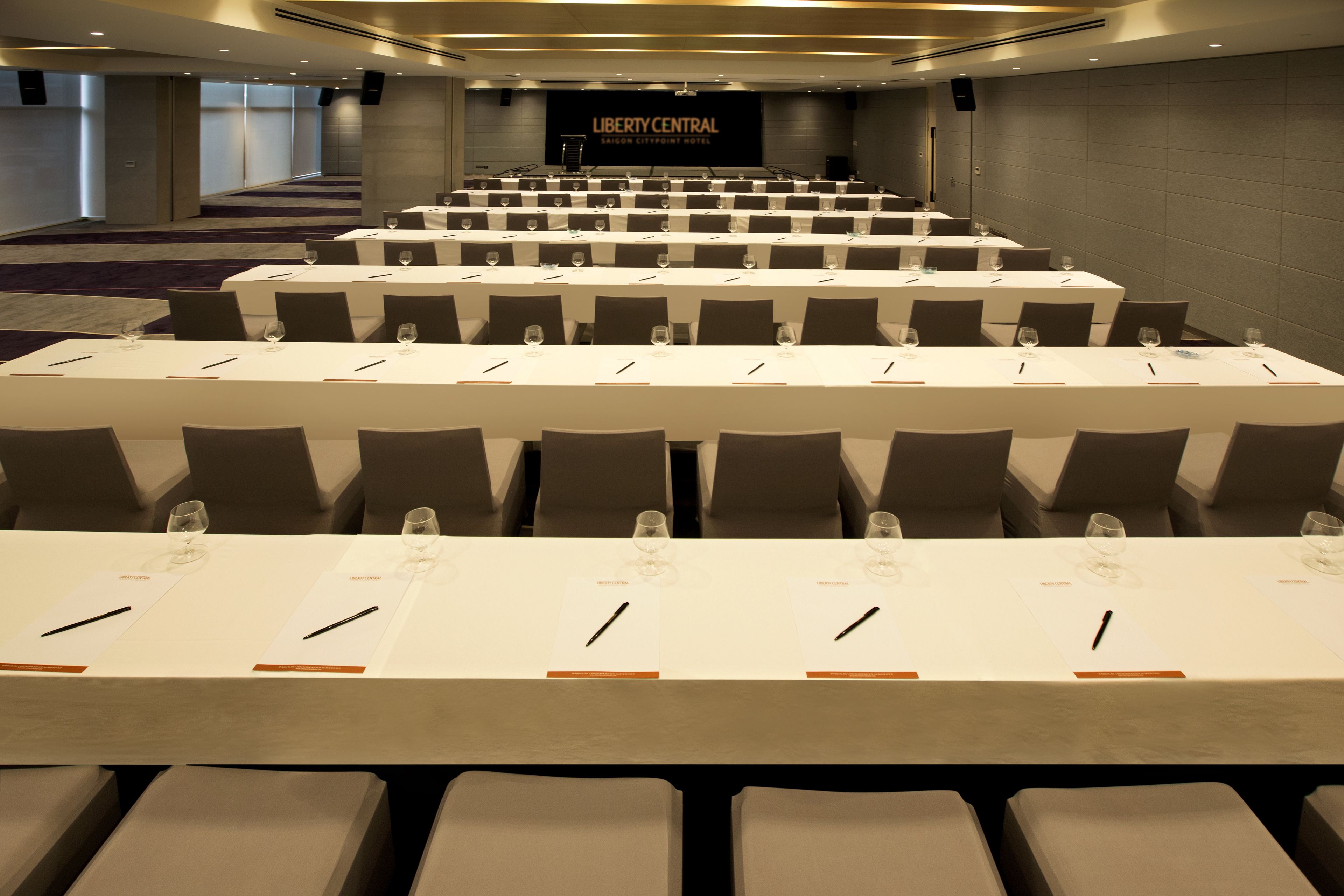 A conference room at Liberty Central with rows of tables, chairs, and name cards.