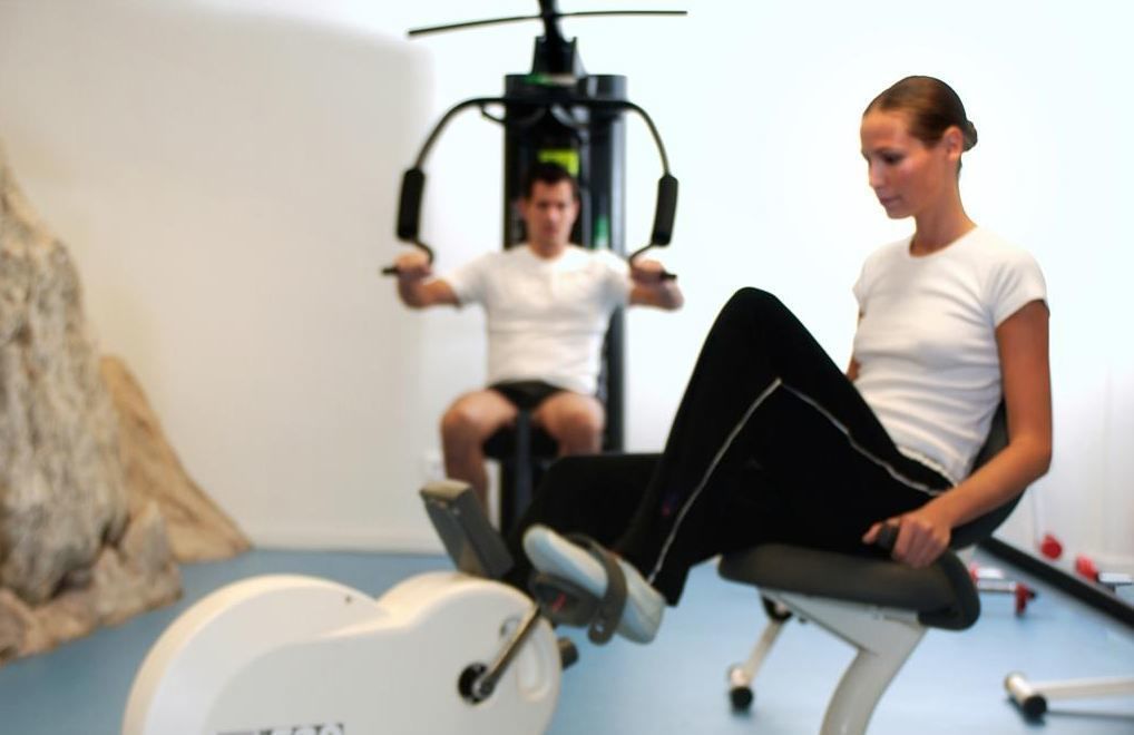 A gym with exercise equipment, including a stationary bike and a weight machine.