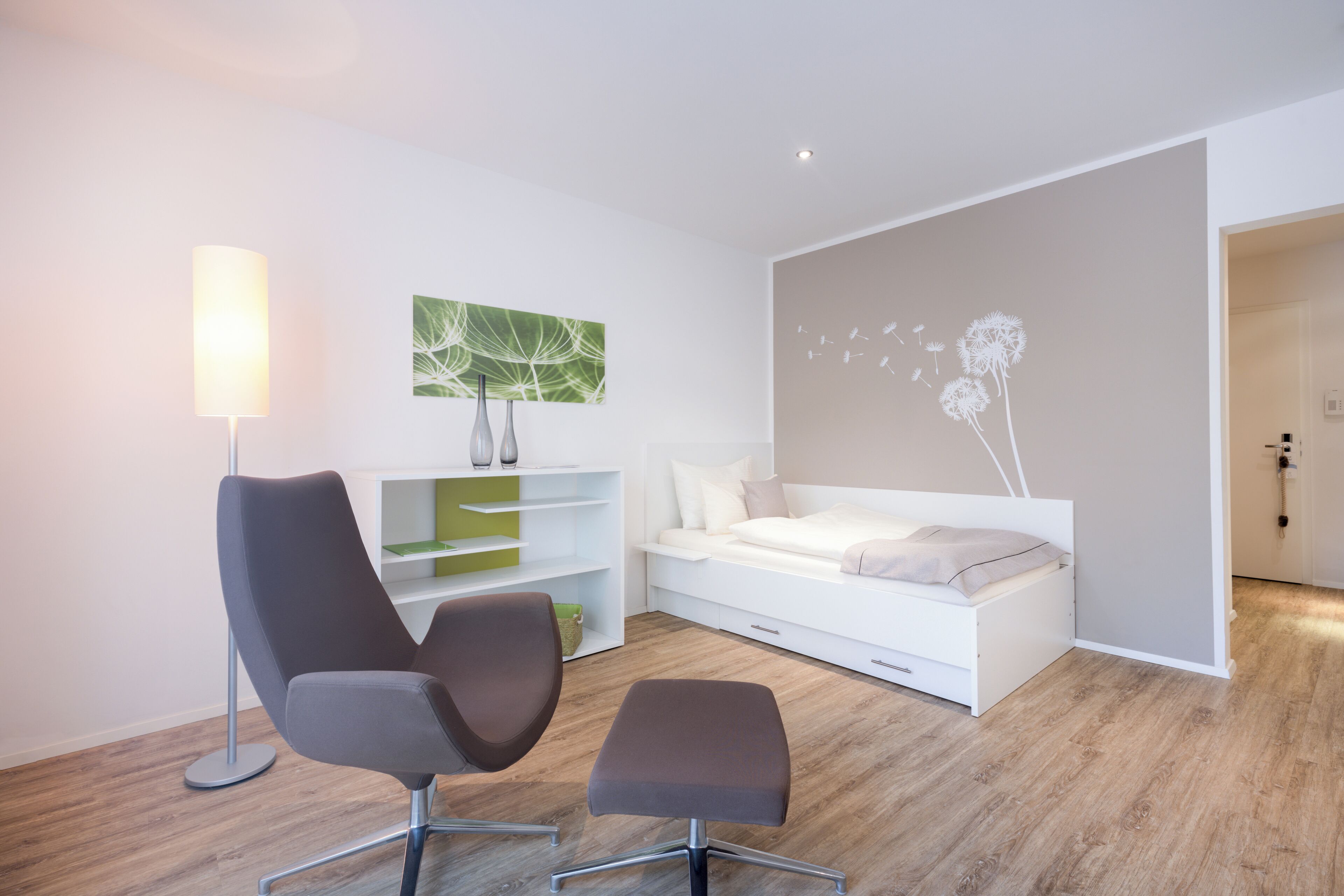 Une chambre à coucher moderne avec un lit, une chaise, un bureau et une lampe.