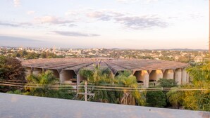 Vista de un paisaje urbano con un edificio moderno grande y una estructura de techo distintiva.