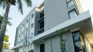 Un edificio moderno de varios pisos con fachada plana, ventanas amplias y un área de balcón.